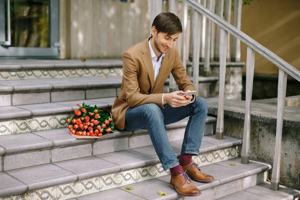 Smiling man texting while looking at the phone — Stock Photo, Image