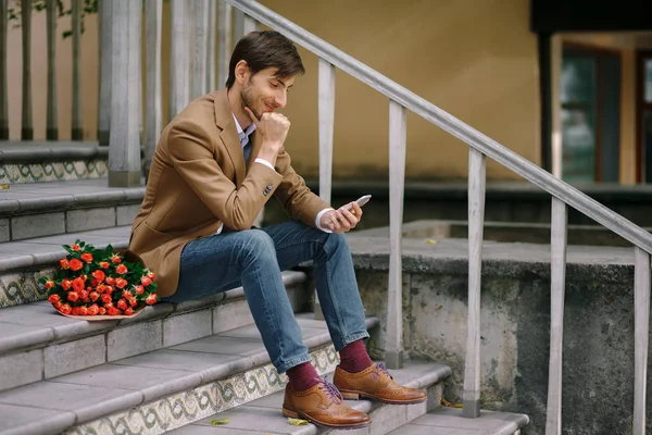 Happy man texting while smiling — Stock Photo, Image