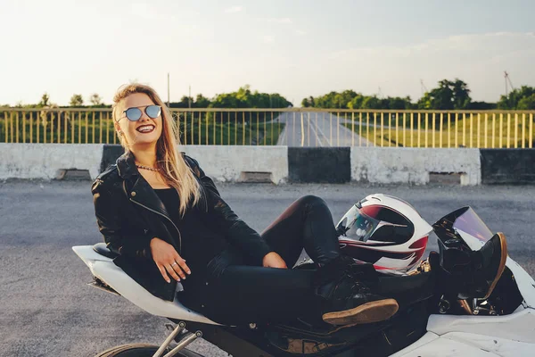 Mulher bonita motociclista que coloca em uma bicicleta relaxante — Fotografia de Stock