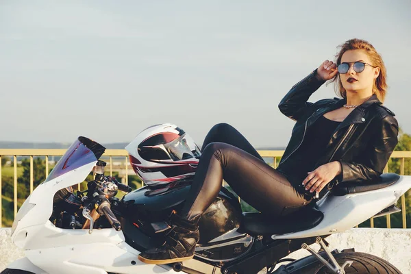 Beautiful woman biker laying on a bike relaxing — Stock Photo, Image