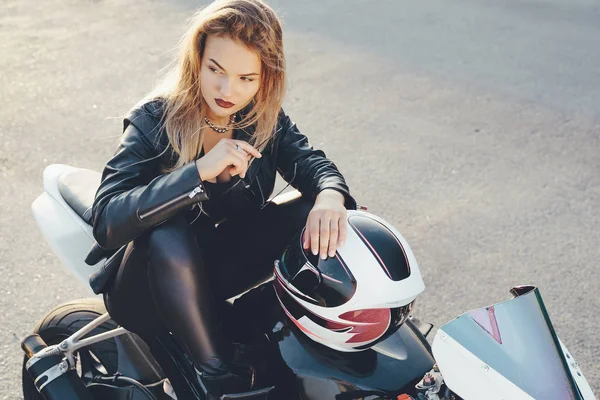 Jovem bela mulher motociclista sentado na moto posando — Fotografia de Stock