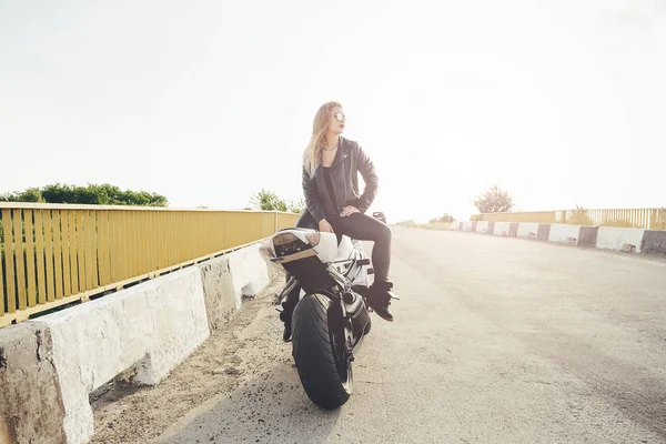 Schöne Radfahrerin posiert auf einem Motorrad sitzend — Stockfoto