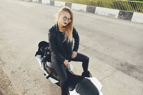 Beautiful woman biker posing sitting on a motorbike — Stock Photo, Image