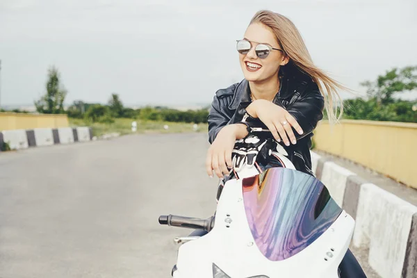 Belle femme posant avec des lunettes de soleil sur une moto — Photo