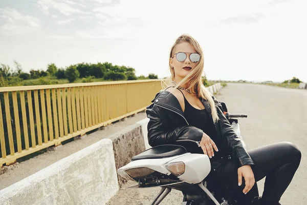 Schöne Frau posiert mit Sonnenbrille auf einem Motorrad — Stockfoto