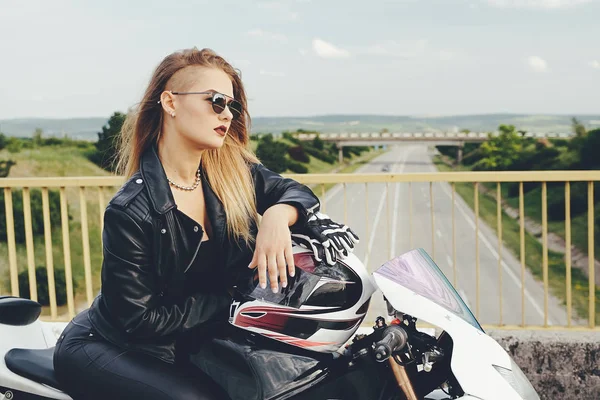 Beautiful woman posing with sunglasses on a motorbike — Stock Photo, Image