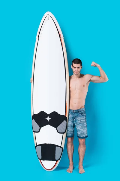Surfista sosteniendo una tabla de surf mostrando su poder — Foto de Stock