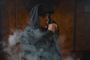 Adam beyaz buharı duman bulutu içinde