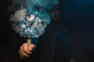Bir elinde duman bulutu yapma damlatıcı