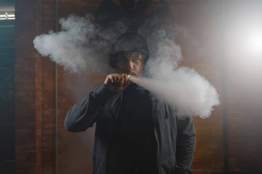 Adam beyaz buharı duman bulutu içinde