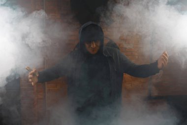 Kendine güvenen adam beyaz buharı duman bulutu içinde