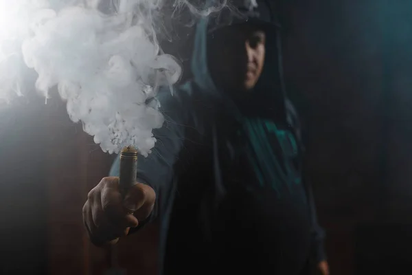 Droppmunstycke i ena handen att göra ett moln av rök — Stockfoto
