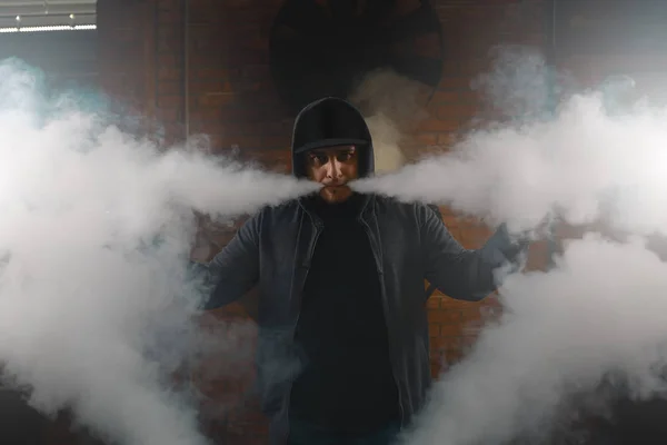 Man making clouds of white vapour with mouth — Stock Photo, Image