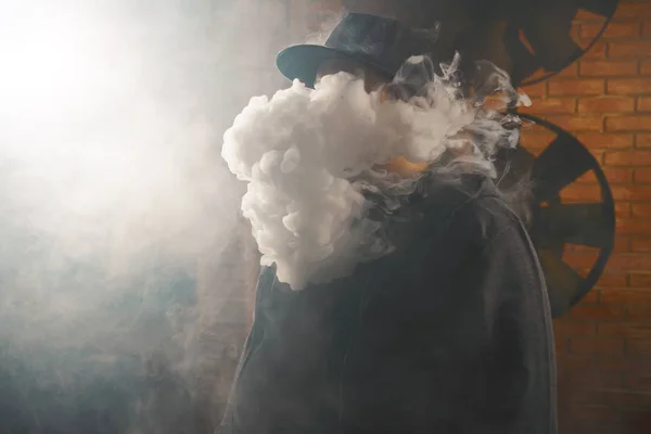 Mannen i ett moln av vita ångor rök — Stockfoto