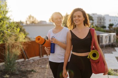 Spor giyimli iki güzel kadın spor antrenmanı, jimnastik ve yoga yapacaklar.