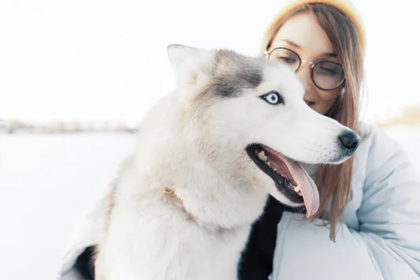 Happy young girl playing with siberian husky dog in winter park — Stock Photo, Image