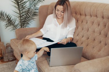 Evde çalışan güzel bir iş kadını. Çoklu görev, serbest meslek ve annelik kavramı
