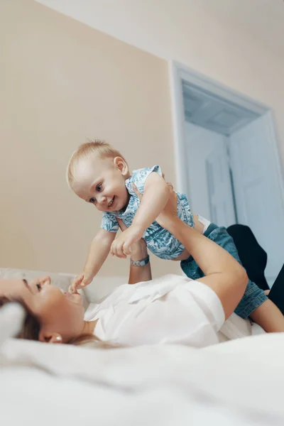 Jeune mère s'amuser à rire en jouant à des jeux actifs drôles avec enfant mignon fils dans la chambre — Photo