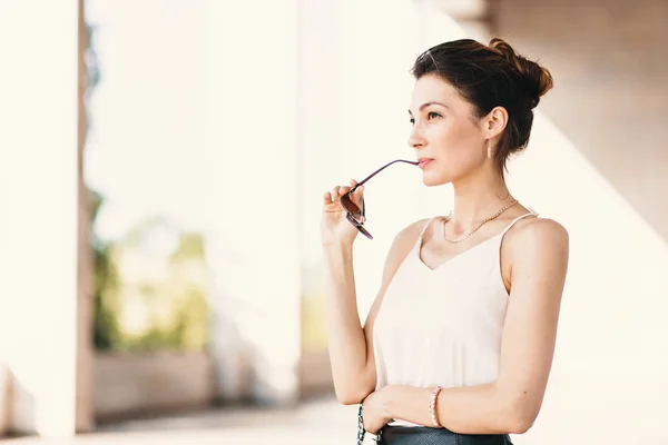 Nahaufnahme Porträt einer jungen, eleganten brünetten Frau in cremefarbener Seidenbluse und Lederrock — Stockfoto