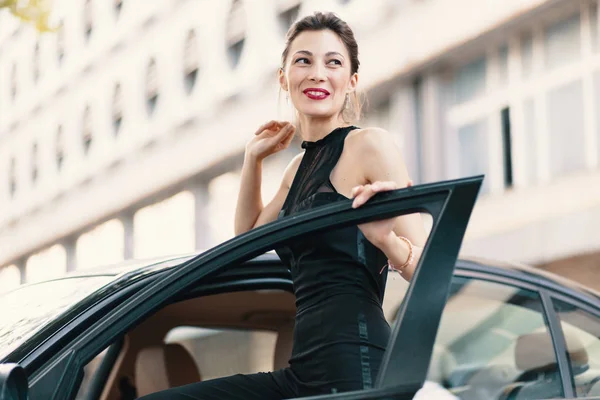 Belle femme riante debout avec un regard heureux dans la porte d'une voiture prête à gagner le monde — Photo