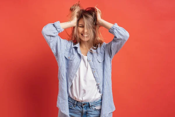 Grappig, schattig meisje plezier tijdens het spelen met haar geïsoleerd op een rode achtergrond — Stockfoto