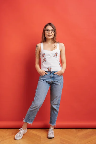 Pretty female model posing with a smiling face expression on red background — Stock Photo, Image