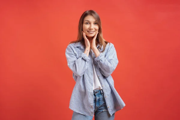 Emoções de pessoas - retrato de menina positiva surpreso sobre fundo vermelho — Fotografia de Stock