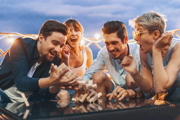 La compañía de jóvenes jugando jenga — Foto de Stock