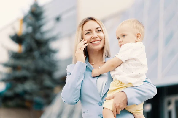 Portrait d'une femme d'affaires réussie en costume bleu avec bébé — Photo