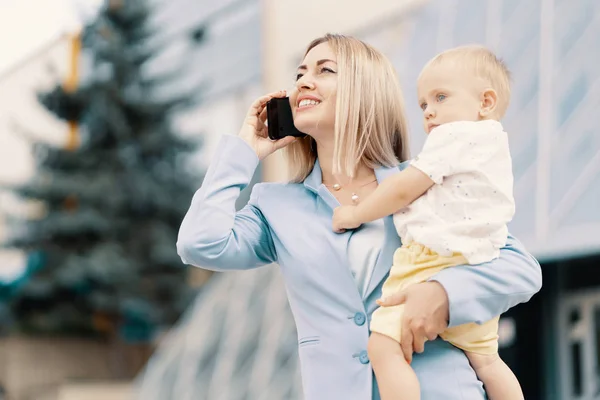 Portrait d'une femme d'affaires réussie en costume bleu avec bébé — Photo