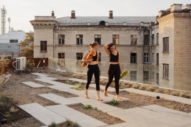 Spor giyimli iki güzel kadın spor antrenmanı, jimnastik ve yoga yapacaklar.
