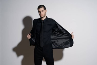 Siyah gömlekli ve siyah takım elbiseli genç yakışıklı iş adamı.