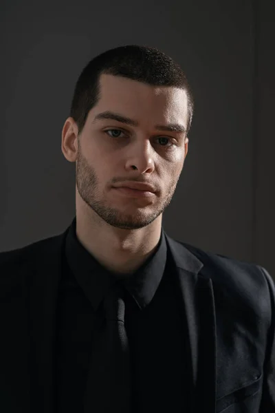 Junger gutaussehender Geschäftsmann im schwarzen Hemd und schwarzem Anzug — Stockfoto