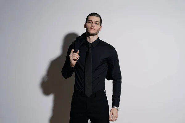 Jeune homme d'affaires beau en chemise noire et costume noir — Photo