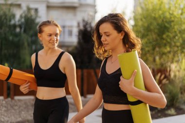 Spor giyimli iki güzel kadın spor antrenmanı, jimnastik ve yoga yapacaklar. Sağlıklı spor yaşam tarzı konsepti. Kadın arkadaşlığı