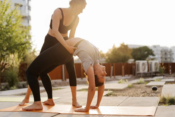 Две Молодые Девушки Практикуют Растяжку Упражнения Йоги Вместе Террасе — стоковое фото