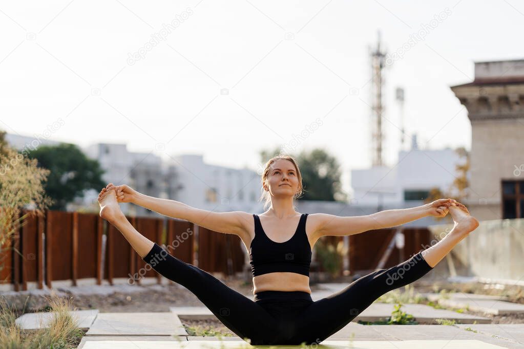 Young girl practicing stretching and yoga workout exercise on the terrace