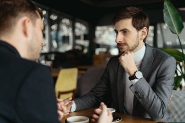 İki genç iş adamı bir şey tartışıyor.