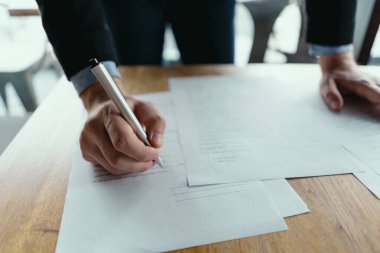 Modern bir ofiste belge imzalayan başarılı bir iş adamı.