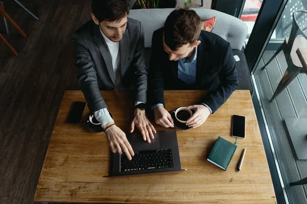 Due uomini d'affari che puntano lo schermo del computer portatile mentre discutono — Foto Stock