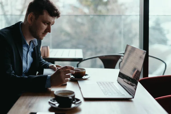 Uomo d'affari che utilizza il computer portatile mentre seduto al tavolo di legno — Foto Stock