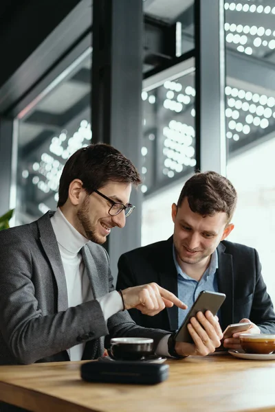 Due uomini d'affari che hanno una conversazione utilizzando uno smartphone — Foto Stock