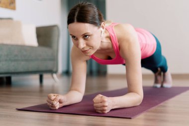 Beyaz kadın evde yoga yapıyor.