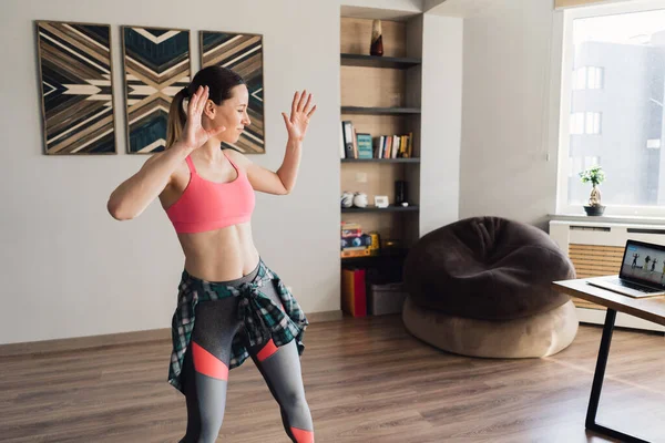 Dizüstü bilgisayardaki video derslerinden sonra dans eden kadın