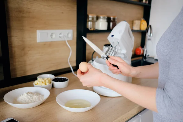 Жінка розбиває курячі яйця в мисці на кухні . — стокове фото