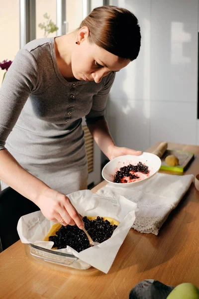 Жінка прикрашає свіжий пиріг ягідним джемом — стокове фото