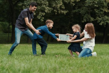 Dört aile üyesi parkta oynarken eğleniyor.