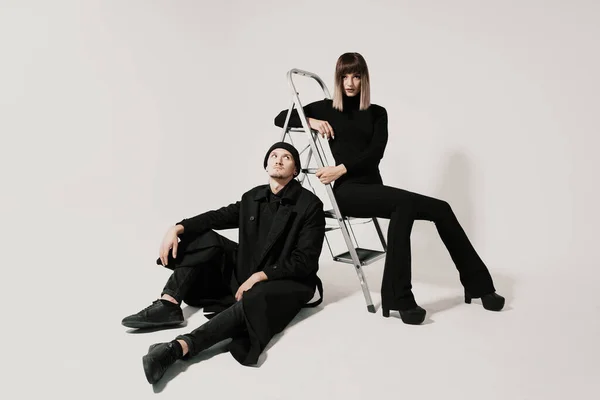Hombre y mujer de moda sentados en una escalera —  Fotos de Stock