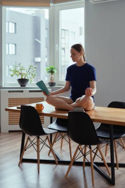 Yoga pozisyonunda okumak masa başında evde kalmak aktivitesidir.