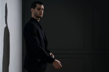 Siyah gömlekli ve siyah takım elbiseli genç yakışıklı iş adamı.